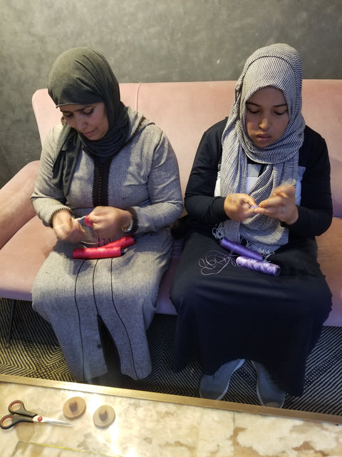 Two women in headscarves, crocheting Mihakkat in red and lilac cotton yarn