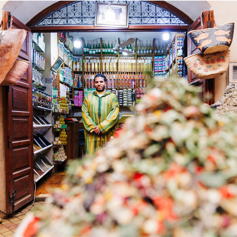 The Herbalist standing in his family's pharmacy with products surrounding him