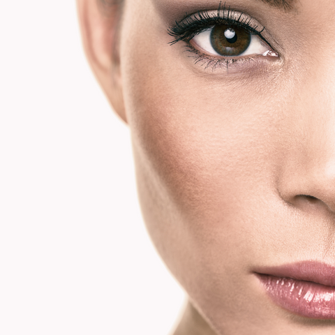 Close up picture of woman with eyeliner, mascara, pink lipstick, and blush