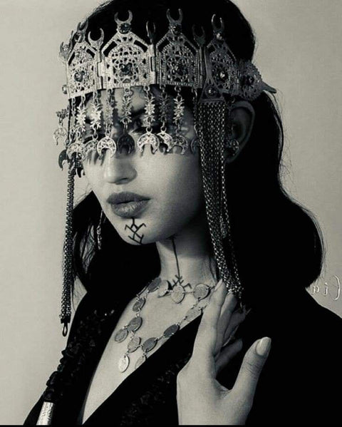 Black and white image of Amazigh woman wearing traditional tribal adornment.