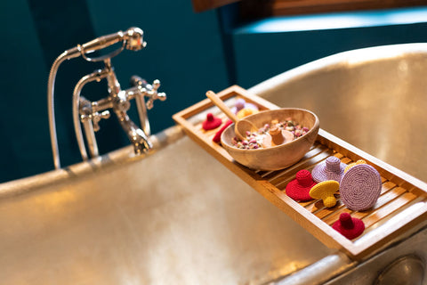 Metal bathtub with tray of dried rose petals and Mihakka exfoliation tools