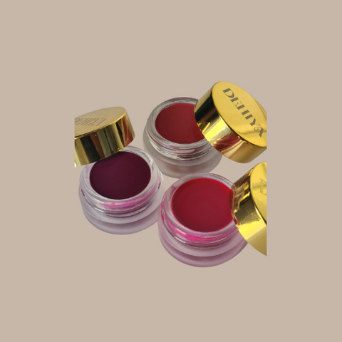 Trio of open Mahiri Lip and Cheek tints with gold caps, colors are red, plum and pink