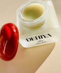 Open jar of DEHIYA Biru Balm, red cap, square frosted jar, light green/blue product